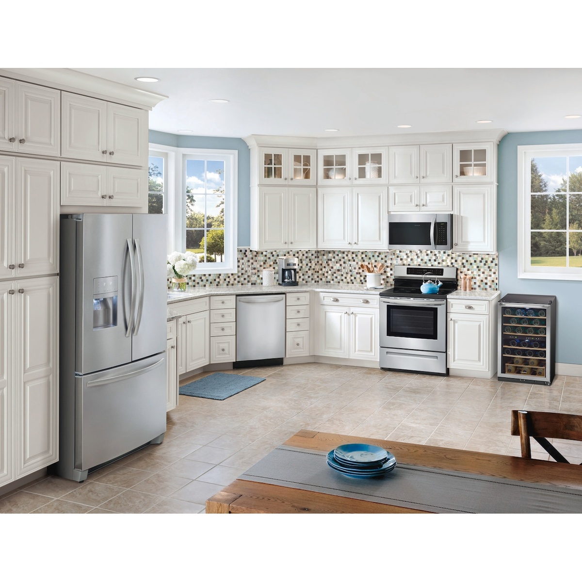 Wine cooler placed in a bright kitchen next to other stainless appliances