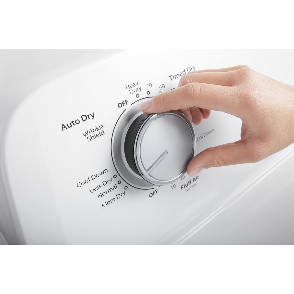 Close-up of a hand turning the Whirlpool dryer cycle dial labeled Auto Dry, Timed Dry, and Wrinkle Shield