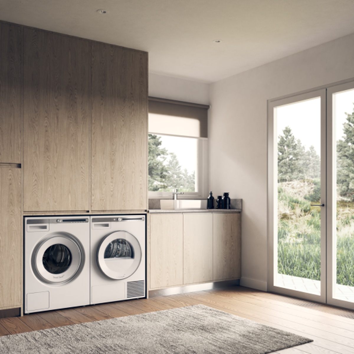 Laundry room with a matching front-load washer and ASKO dryer installed under a wood countertop