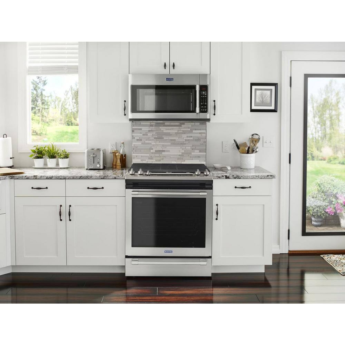 Maytag slide-in gas range installed in a white kitchen