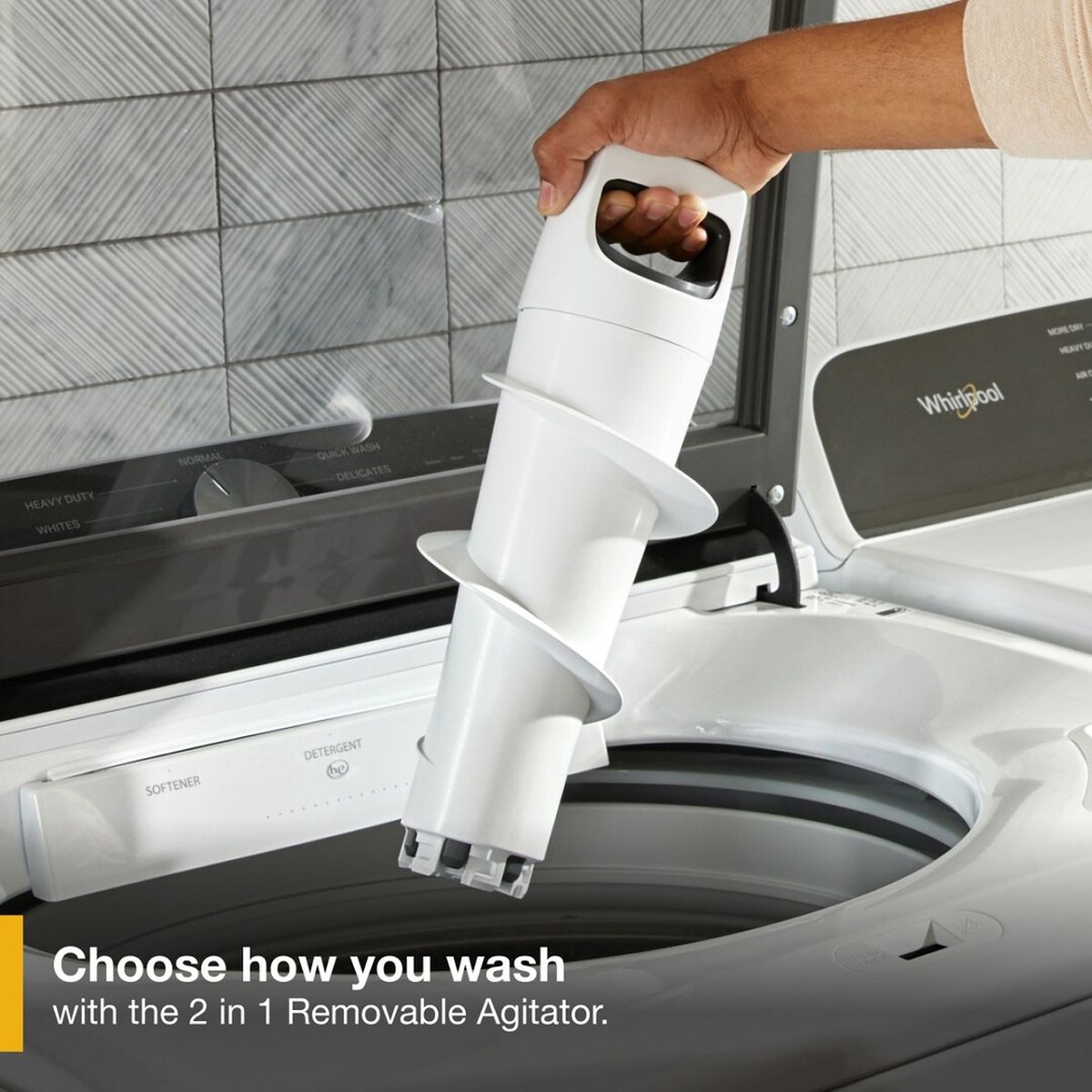 Hand lifting the removable agitator out of the Whirlpool top load washer drum