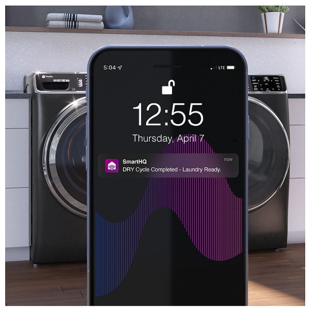 Smartphone showing a SmartHQ dry cycle completed notification in front of a matching laundry pair