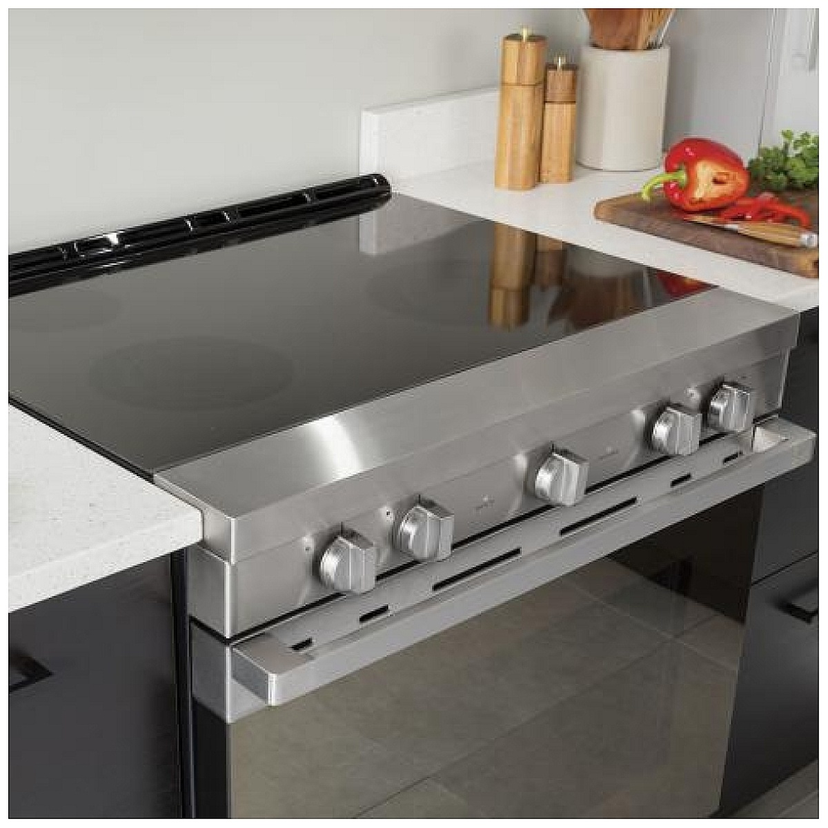 Haier slide-in electric range installed between countertops showing the front control knobs and smooth cooktop