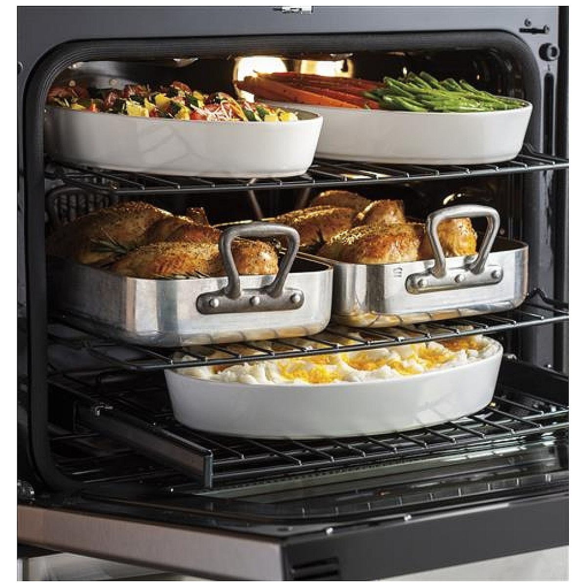 Oven interior with multiple racks holding roasting pans and casserole dishes