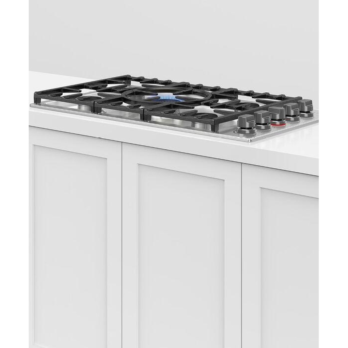 Angled view of the Fisher Paykel gas cooktop installed in a countertop, showing the row of control knobs