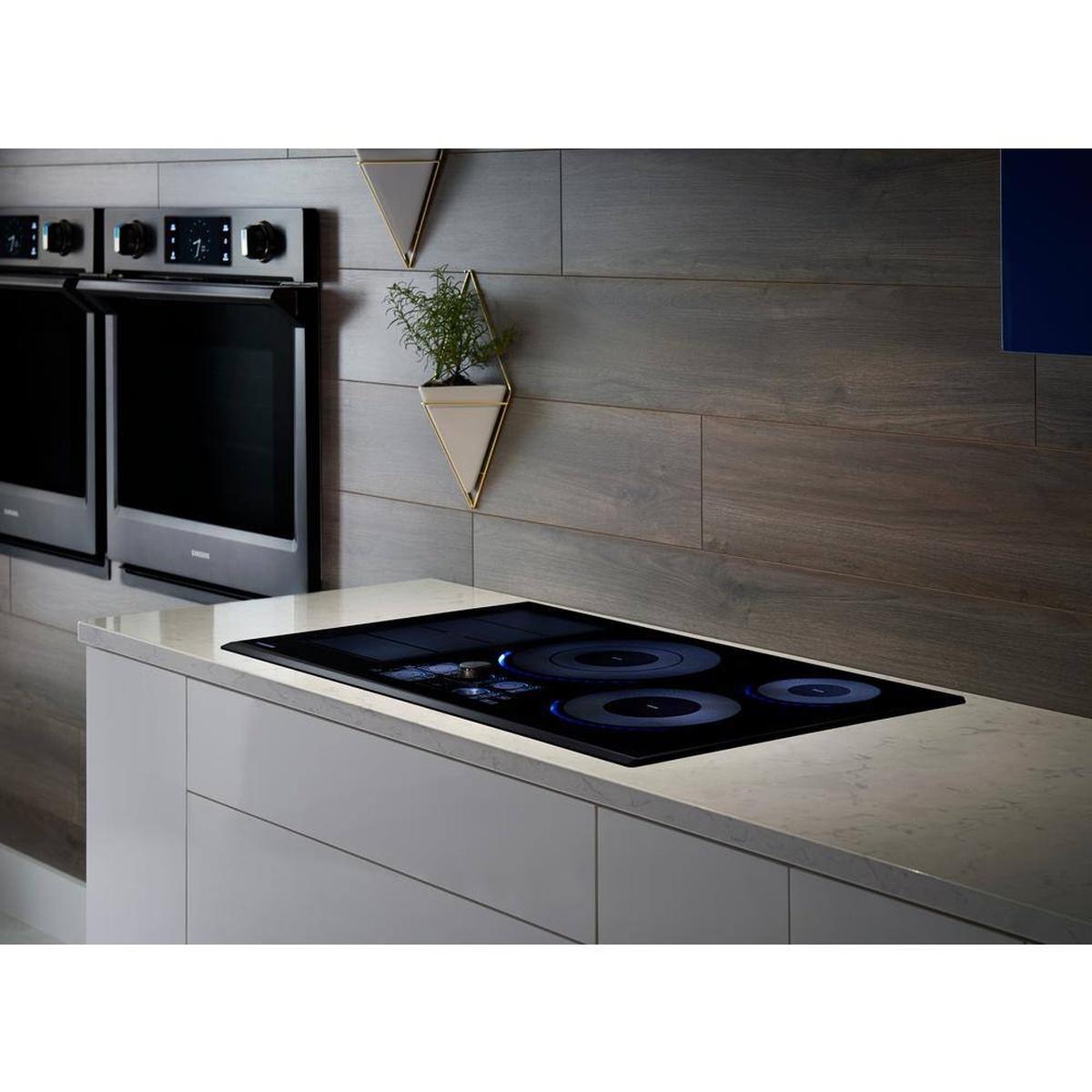 Samsung induction cooktop installed flush in a modern countertop with blue LED lights illuminated