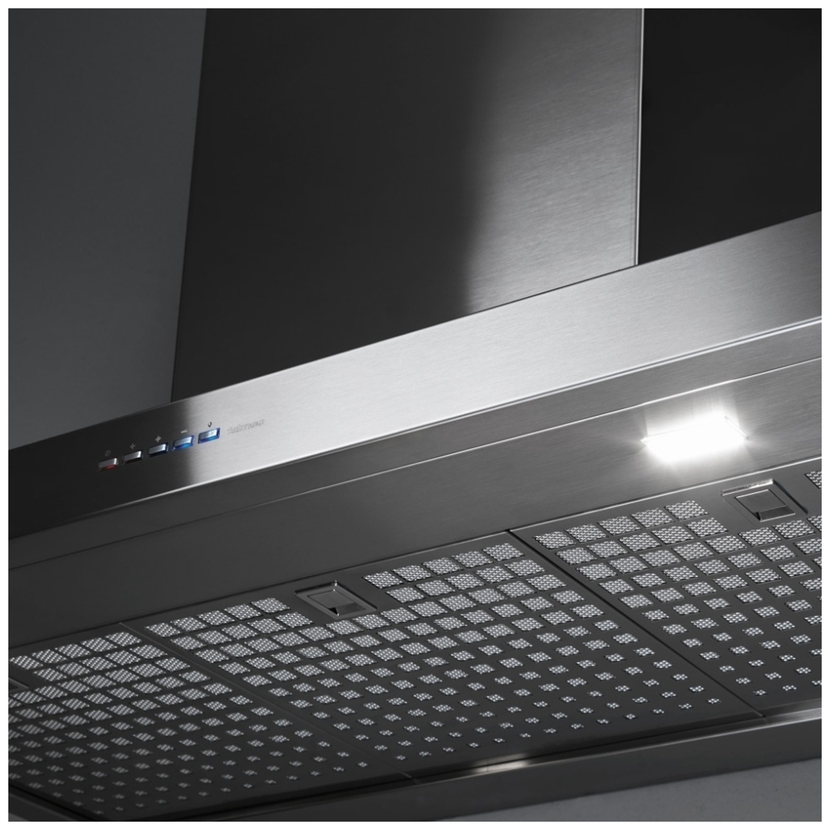 Close-up underside view of the stainless wall-mount range hood showing push-button controls, LED light, and mesh filter panels