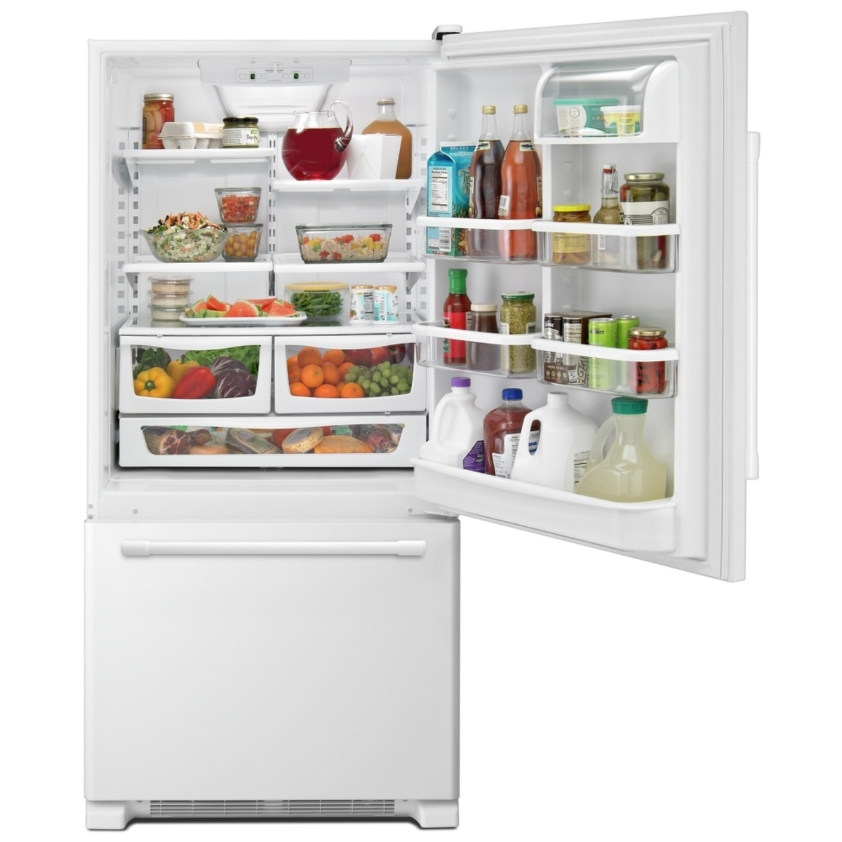 Open Maytag bottom-freezer refrigerator with food loaded on glass shelves, door bins, and two crispers above a full-width deli-style drawer
