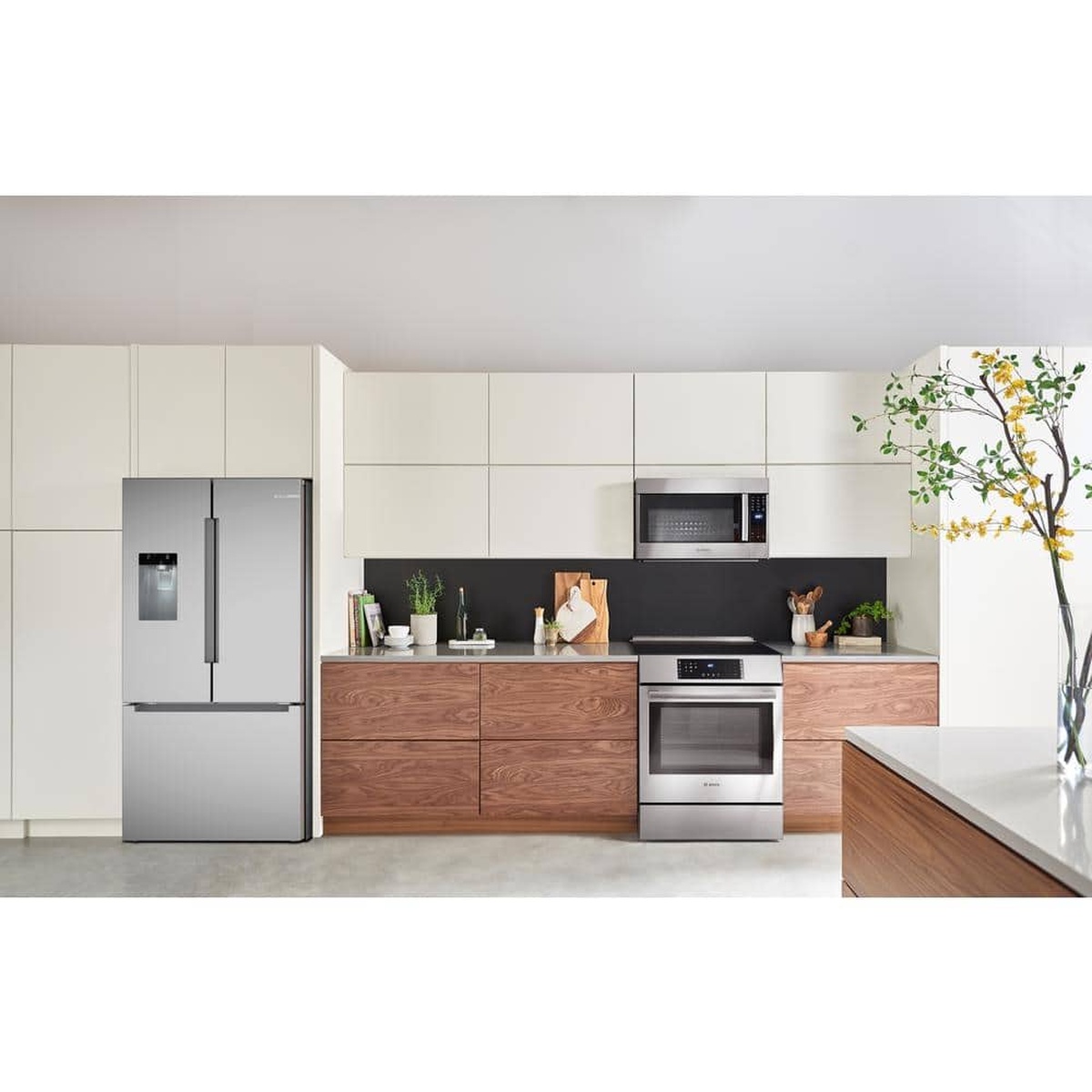 Stainless steel French door refrigerator installed in a modern kitchen with matching Bosch cooking appliances