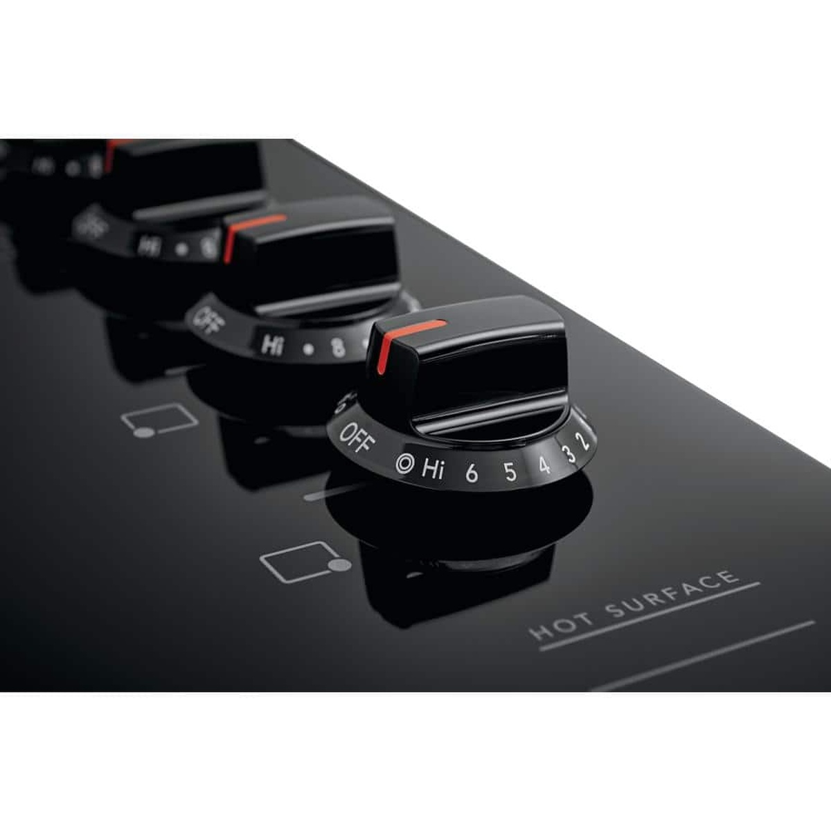 Close-up of the Frigidaire cooktop control knobs with numbered heat settings on the black glass surface