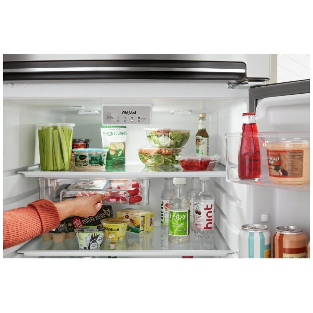 Inside the refrigerator compartment showing adjustable glass shelves, interior controls, and a sliding bin