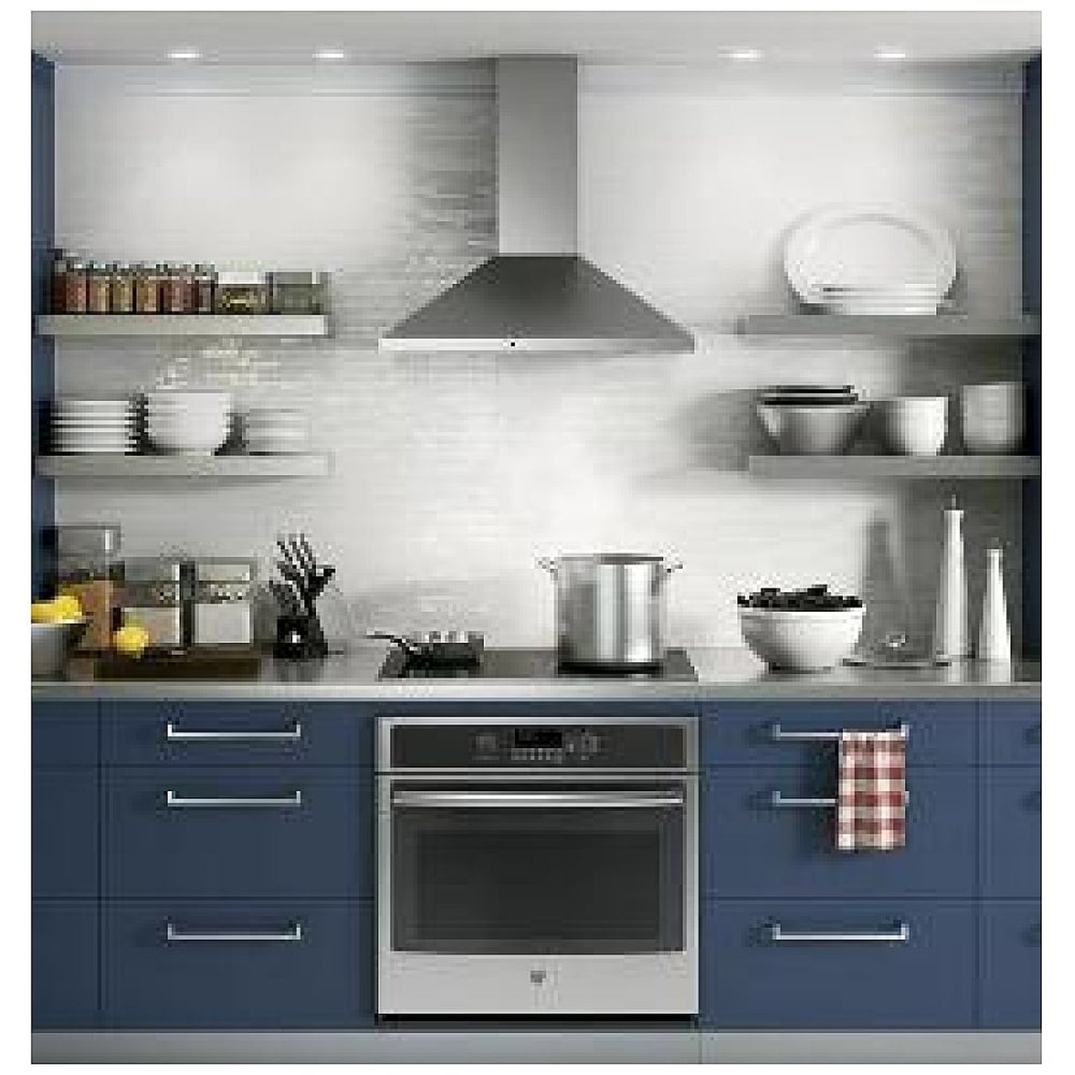 Stainless wall-mount chimney range hood installed above a cooktop in a modern kitchen
