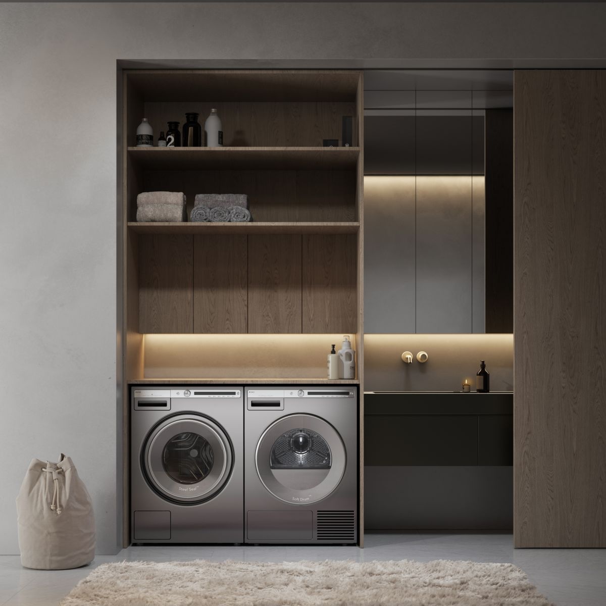 Built-in laundry setup showing an ASKO washer and dryer side by side under shelving in a modern cabinet niche