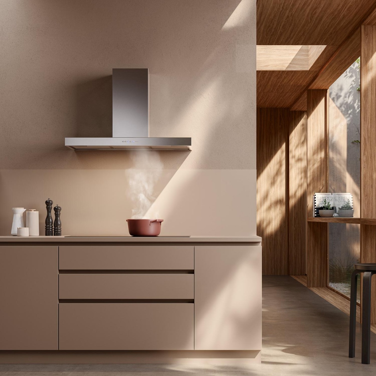 Modern kitchen scene showing a stainless steel wall-mounted range hood above a cooktop with steam rising from a pot