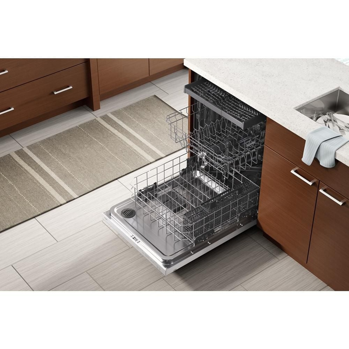 Open built-in dishwasher installed in a kitchen, showing the third rack, middle rack, and lower rack pulled out