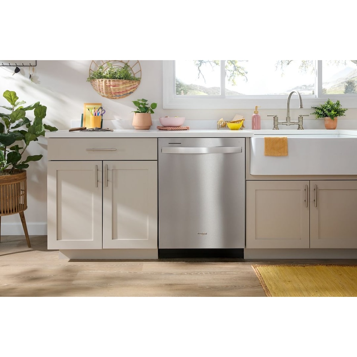 Whirlpool WDT750SAKZ stainless steel dishwasher installed in a bright white kitchen alongside white cabinetry and a farmhouse sink