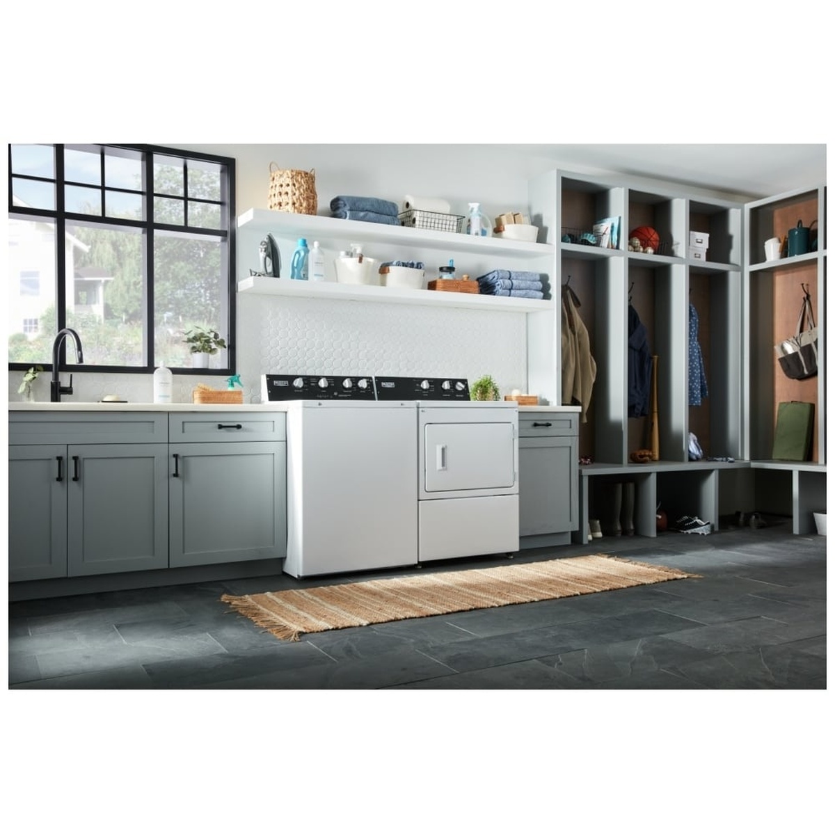 Maytag top-load washer installed in a home laundry room with cabinetry and shelves