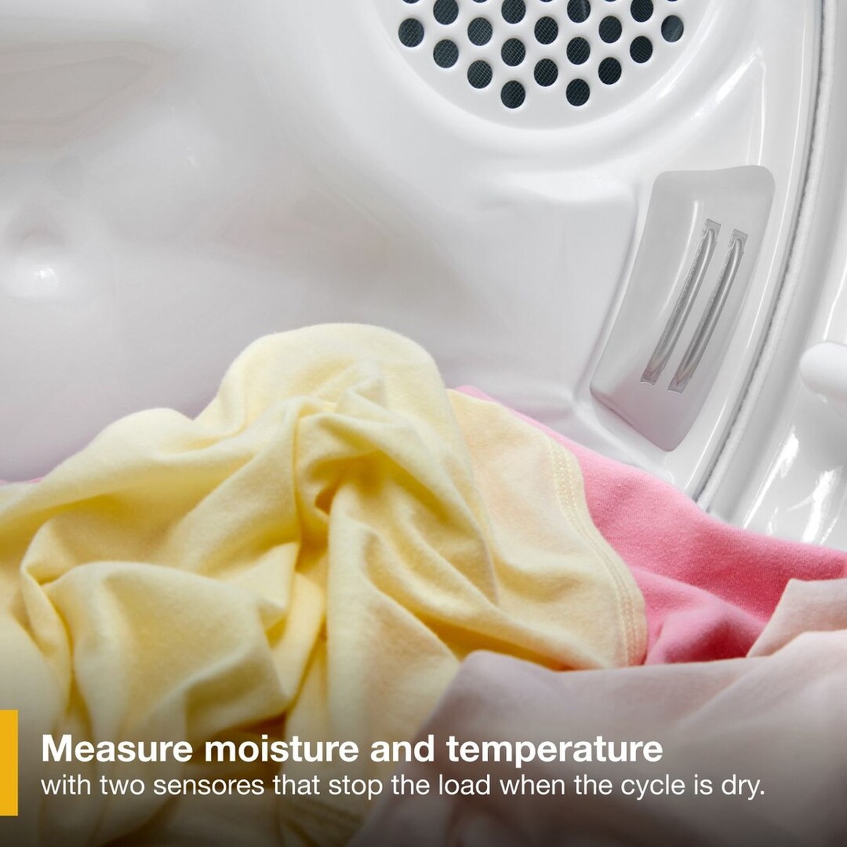 Close-up of laundry inside the dryer drum with on-screen text reading: Measure moisture and temperature with two sensors that stop the load when the cycle is dry.