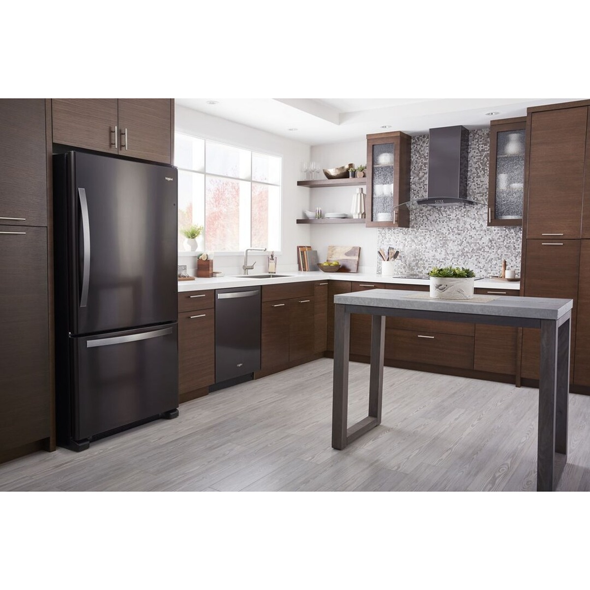 Whirlpool Black Stainless bottom-freezer refrigerator installed in a modern kitchen with dark wood cabinetry, open shelving, and a kitchen island.