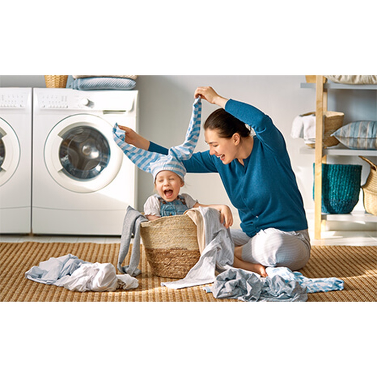 Person sorting laundry in a laundry room with a front-load washer and dryer in the background