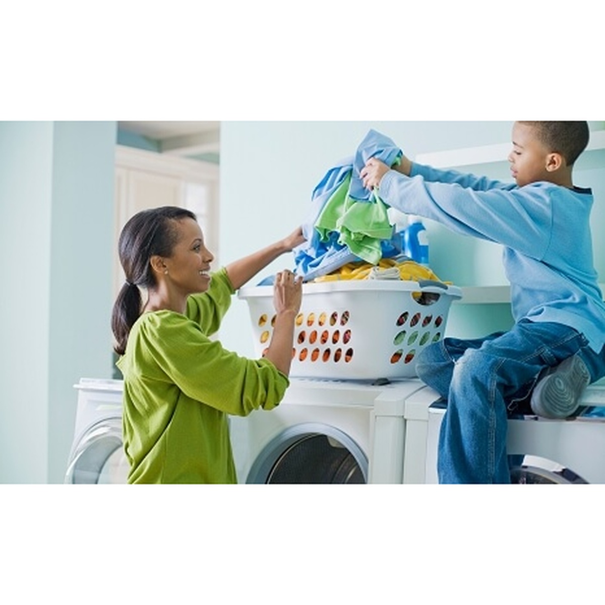 Family placing clothes into a laundry basket near a front-load washer