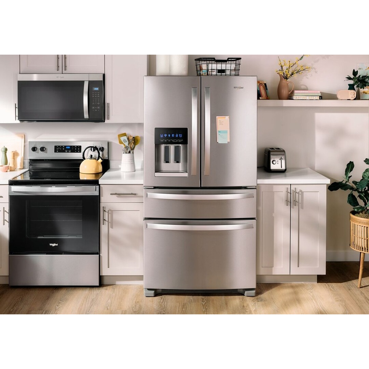 Whirlpool WRMF3636RZ stainless steel French door refrigerator in a bright modern kitchen alongside a matching Whirlpool electric range and over-the-range microwave