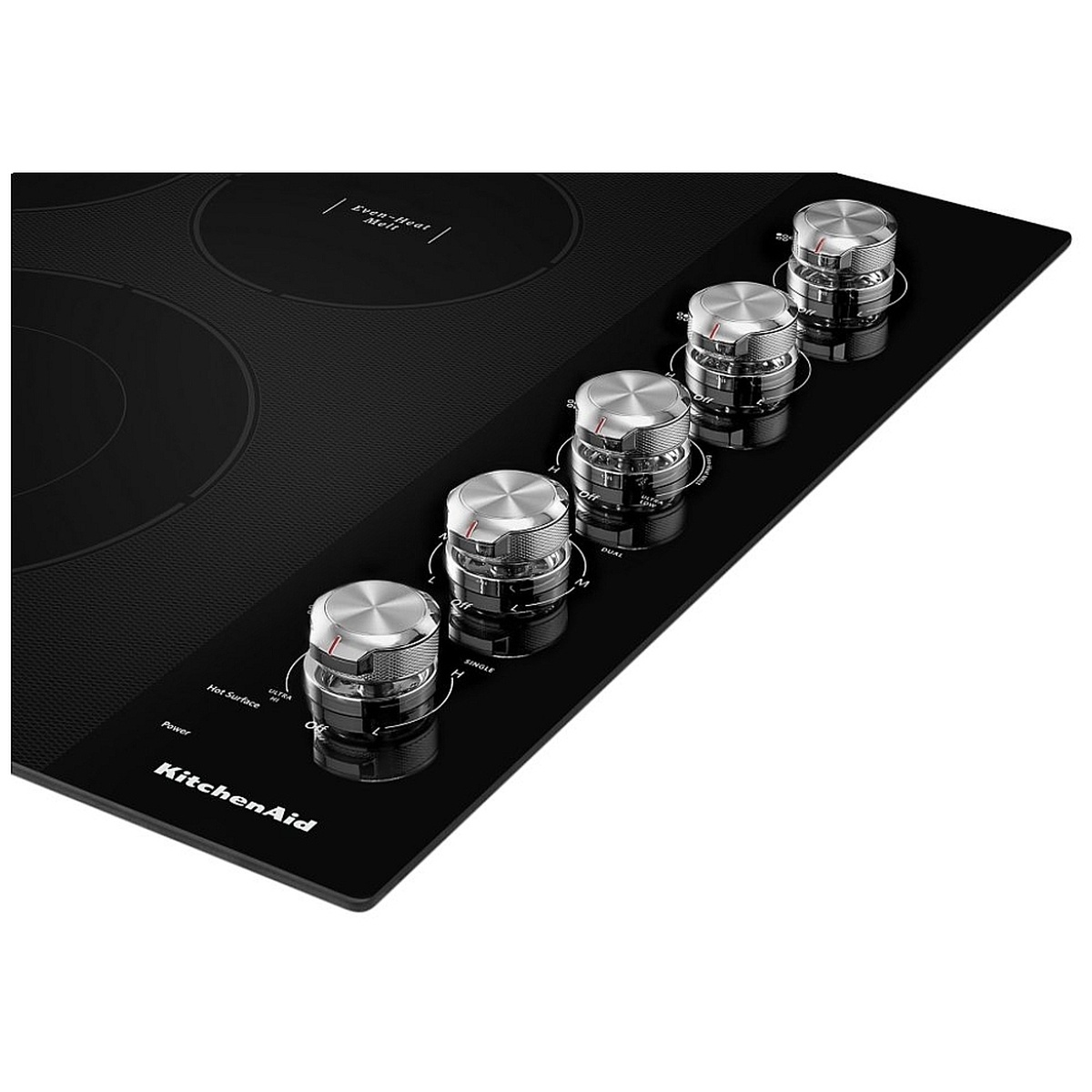 Close-up of five stainless steel metal control knobs on the KitchenAid KCES550HBL black glass cooktop, showing Hot Surface and Power indicator labels