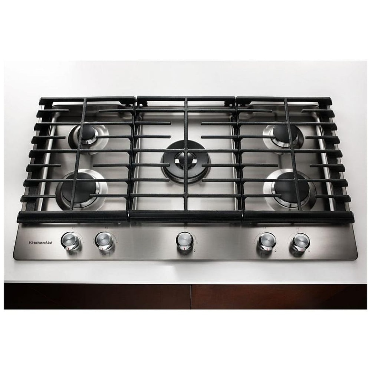 KitchenAid stainless steel gas cooktop installed in a countertop with front control knobs