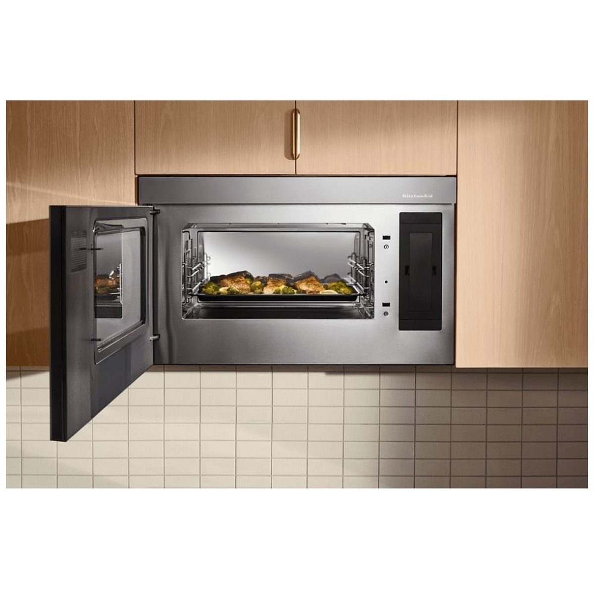 KitchenAid YKMMF530PPS installed above range in a modern kitchen with door open and salmon fillets with vegetables cooking on the interior rack
