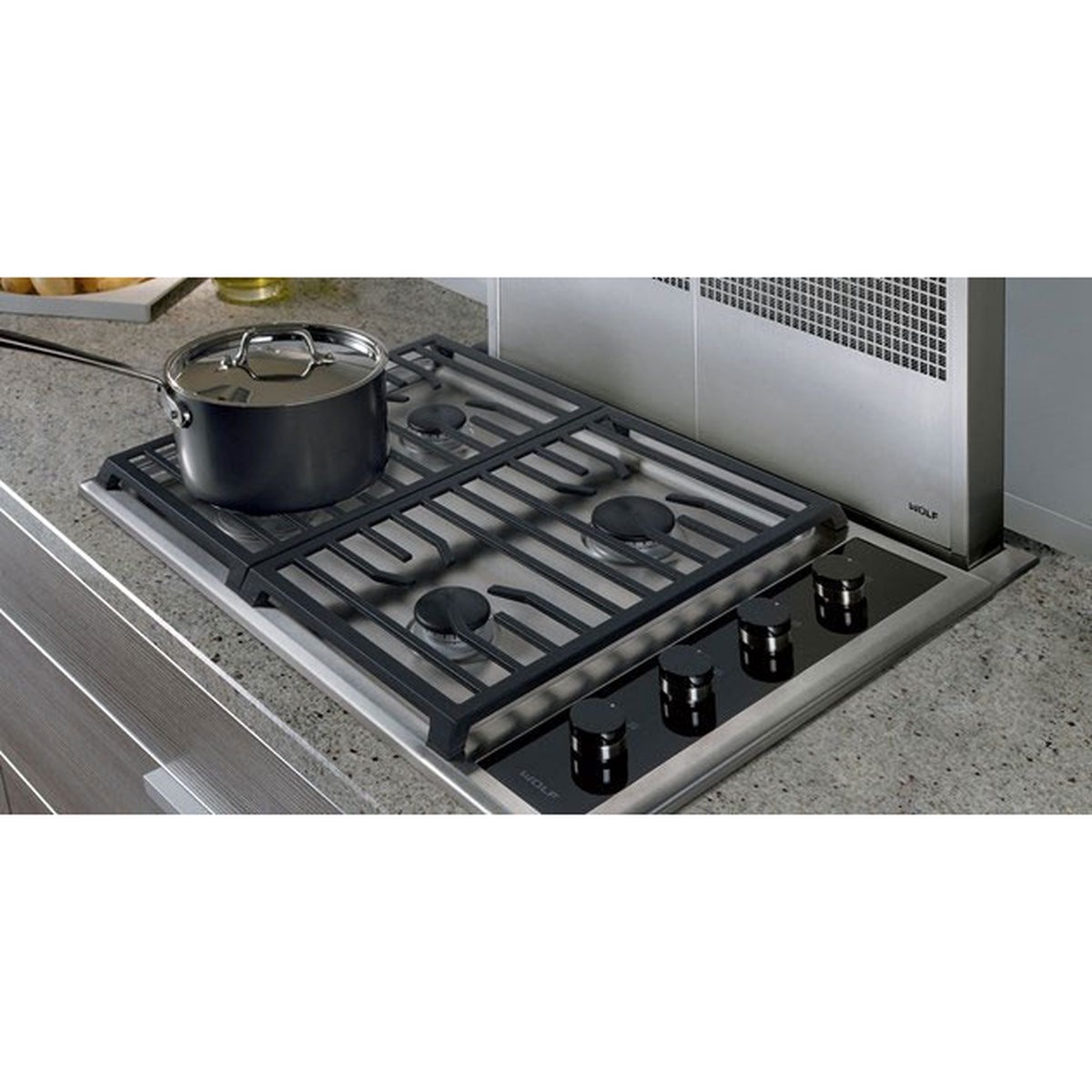 Wolf gas cooktop installed in a countertop with a large pot on the left grate and four control knobs on the right