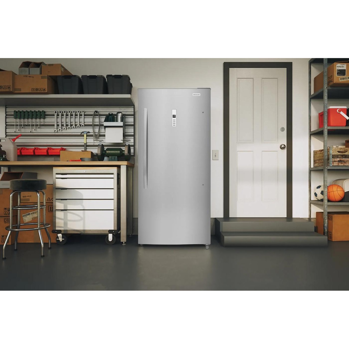 Upright freezer placed in a garage setting with smooth stainless look door and front control panel