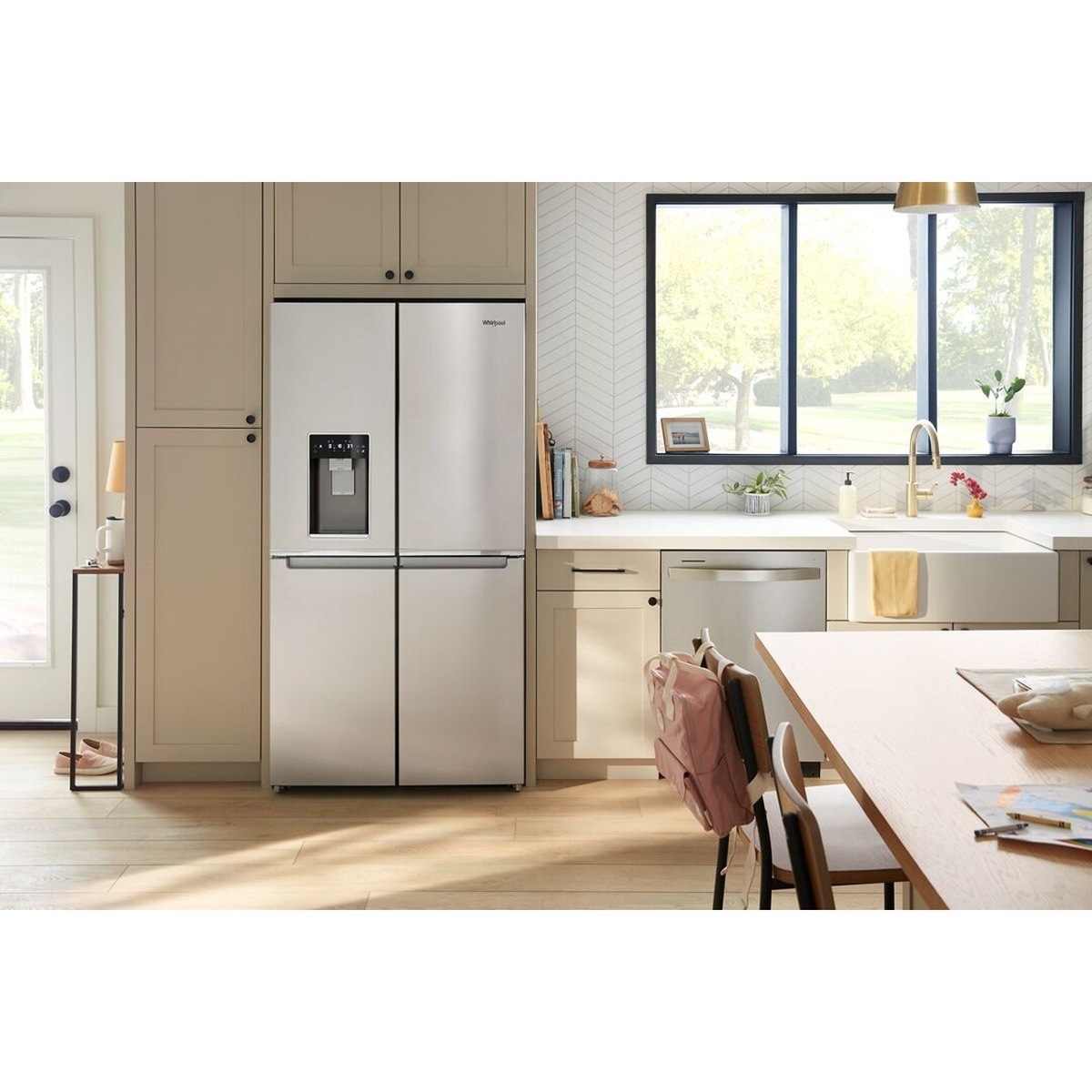 Whirlpool WRQC7836RZ installed flush with cabinetry in a bright, modern kitchen with white countertops and a casual dining area visible in the background