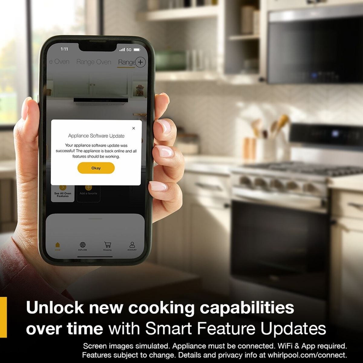 Hand holding a smartphone showing an appliance software update message, with a Whirlpool range in the background