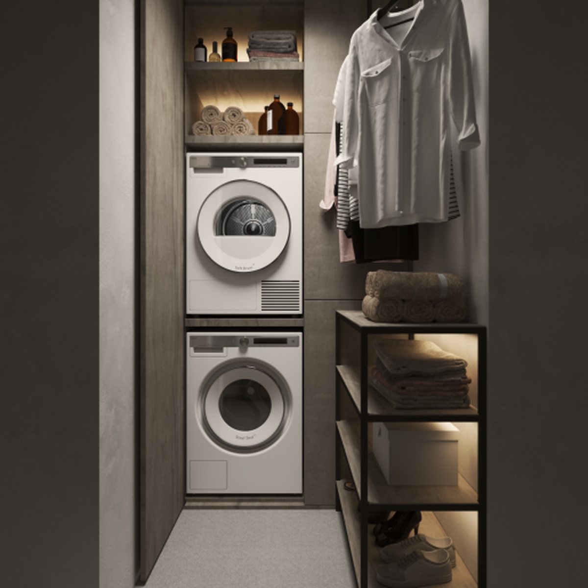 ASKO dryer stacked on top of a washer inside a modern built-in laundry closet with shelving and hanging garments