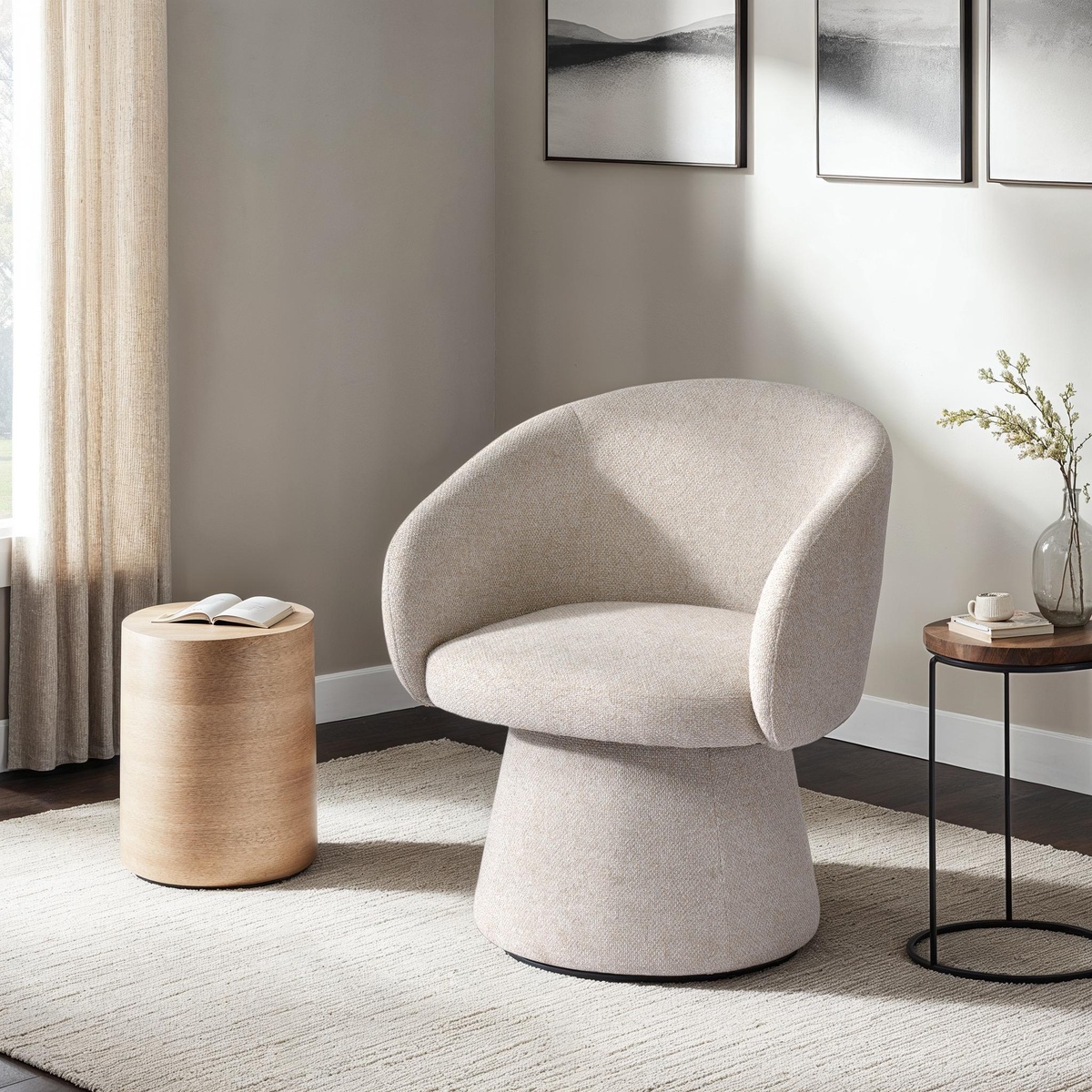 Misha Club Chair styled in a bright, neutral living room alongside a round wood side table and minimalist decor, showing its sculptural pedestal silhouette in a real-space context