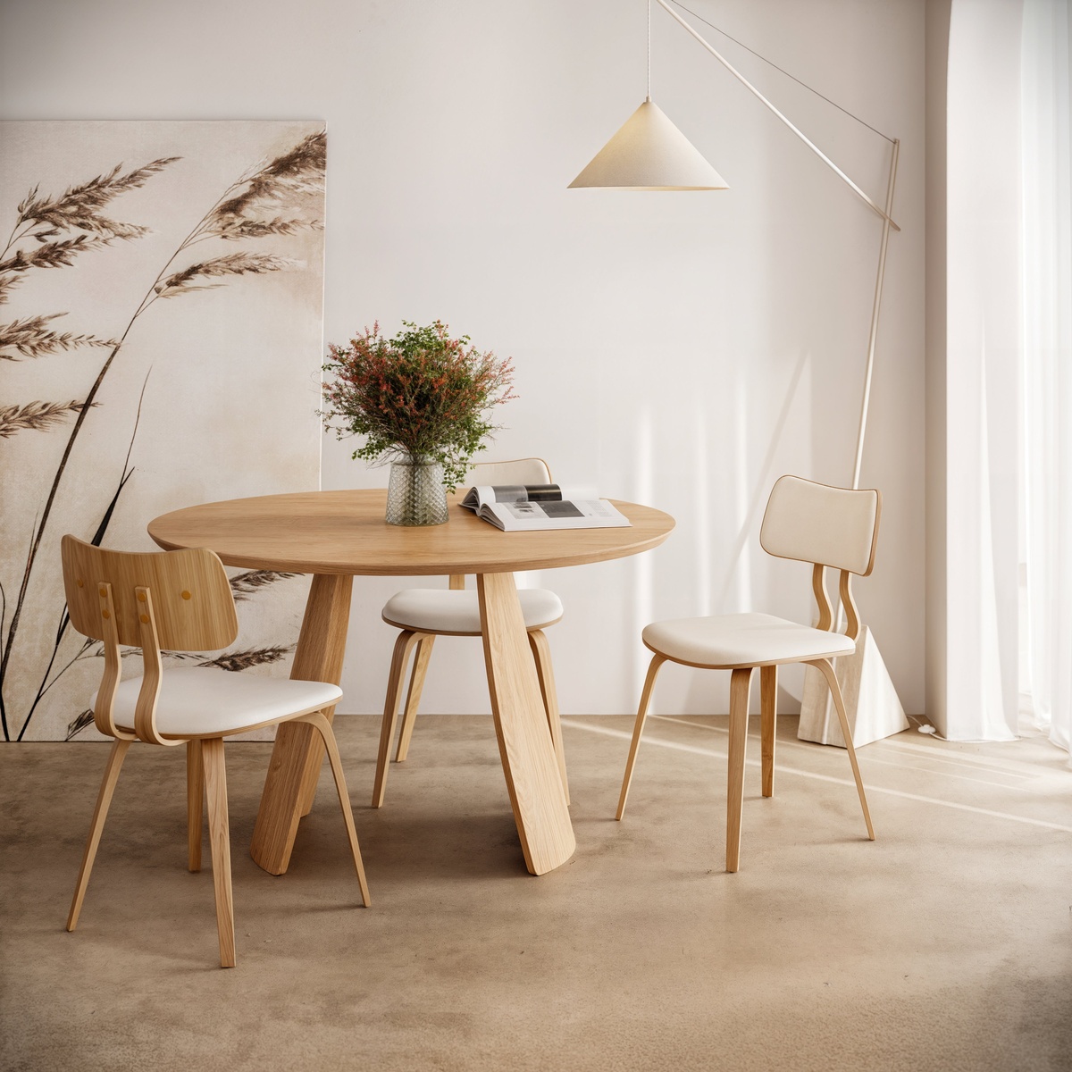 Obelia Oak dining table styled in a bright, neutral dining room with three wood-and-cream upholstered chairs, a floral centerpiece, and a pendant light overhead