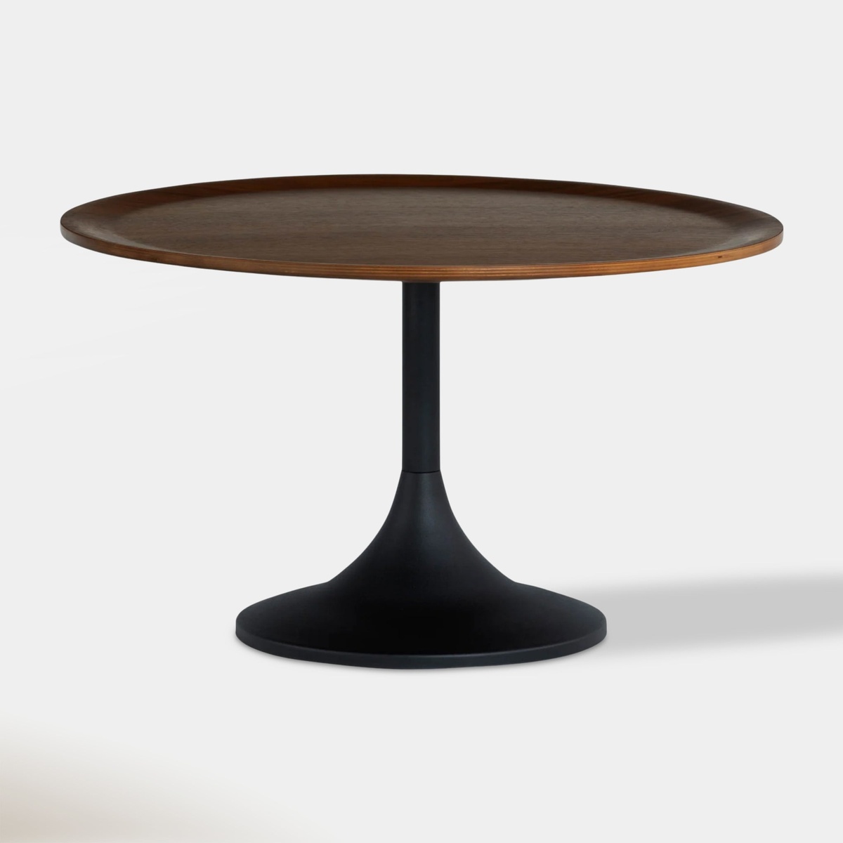 HOFT Davos Coffee Table in walnut finish showing round oak top and black tulip-shaped metal pedestal base against a white background