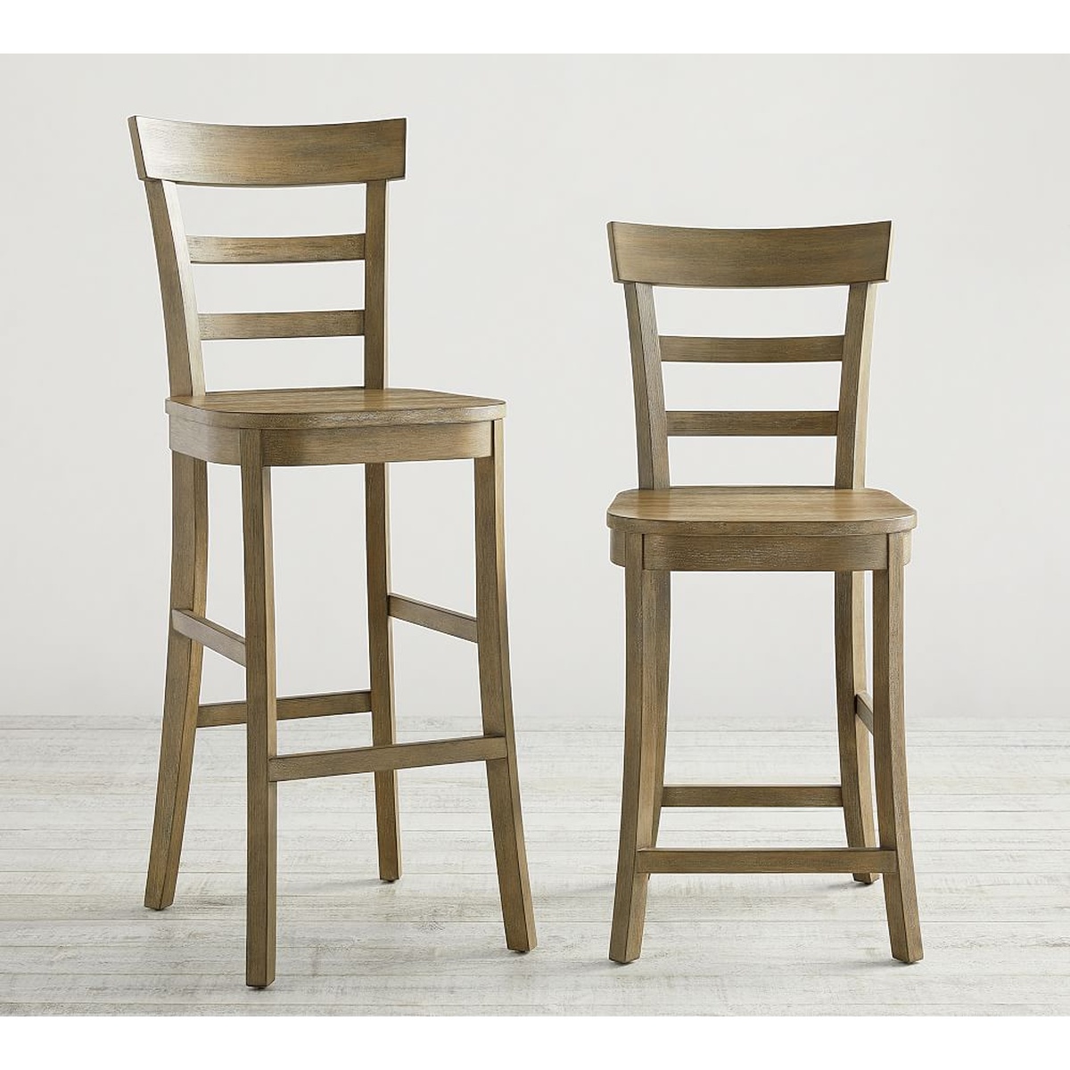 Liam bar stool and counter stool side by side in Weathered Grey finish on a light neutral background showing both height options