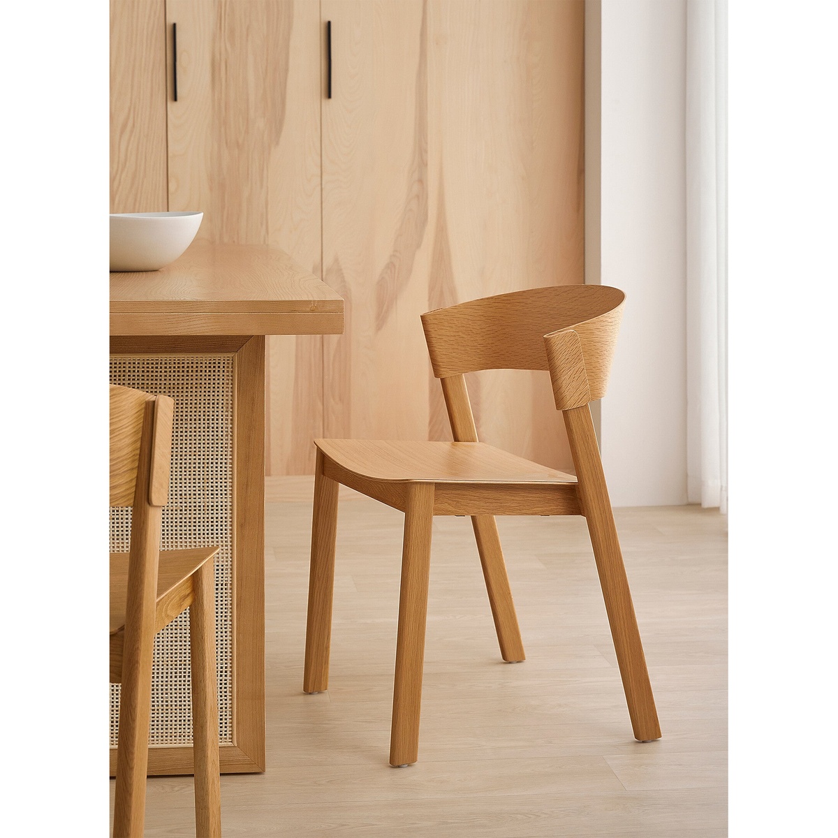 Aldo Dining Chair in Oak styled beside a light wood dining table in a warm, Scandinavian-inspired dining space