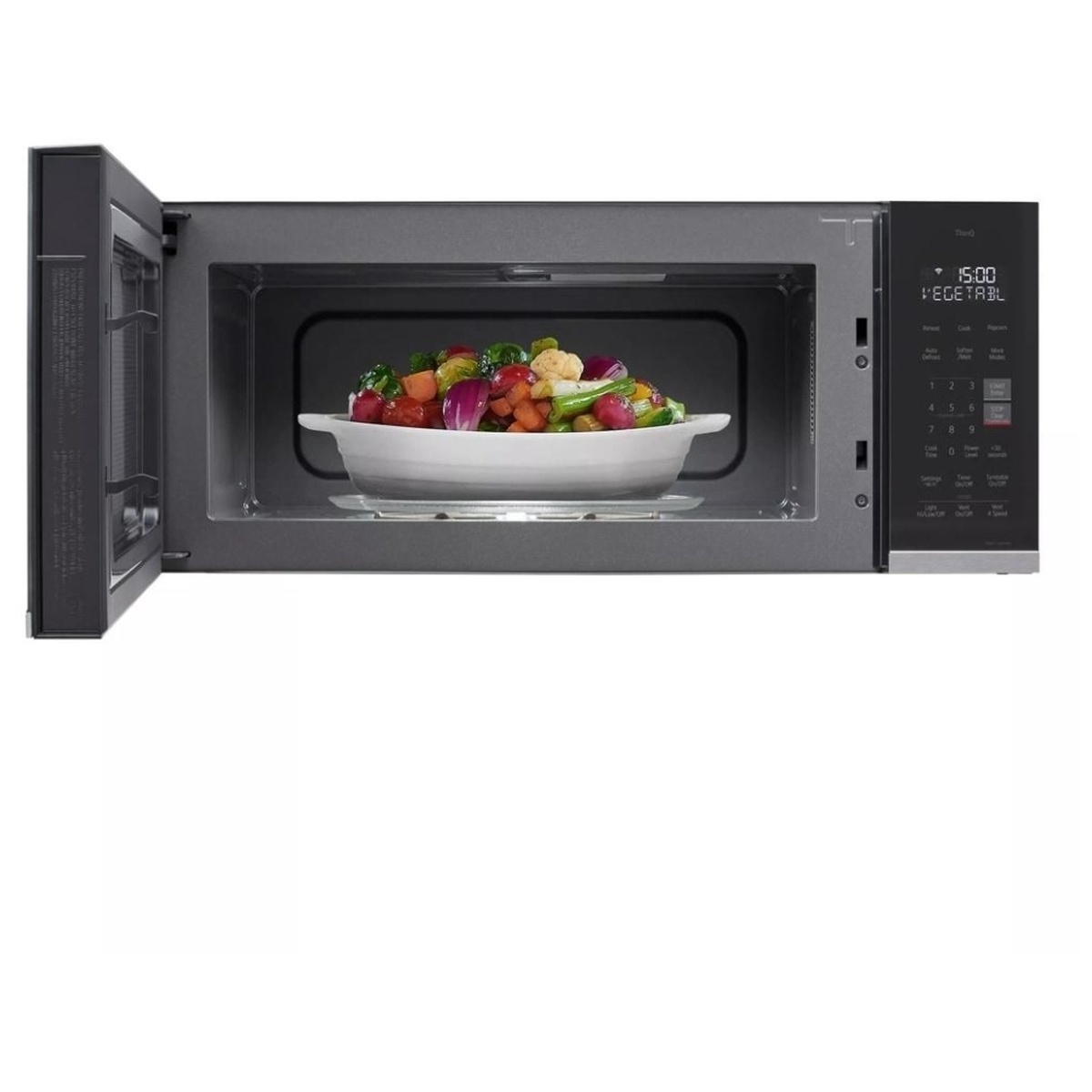 LG MVEF1323F interior open showing a large white dish filled with colorful roasted vegetables inside the spacious 1.3 cu. ft. cavity