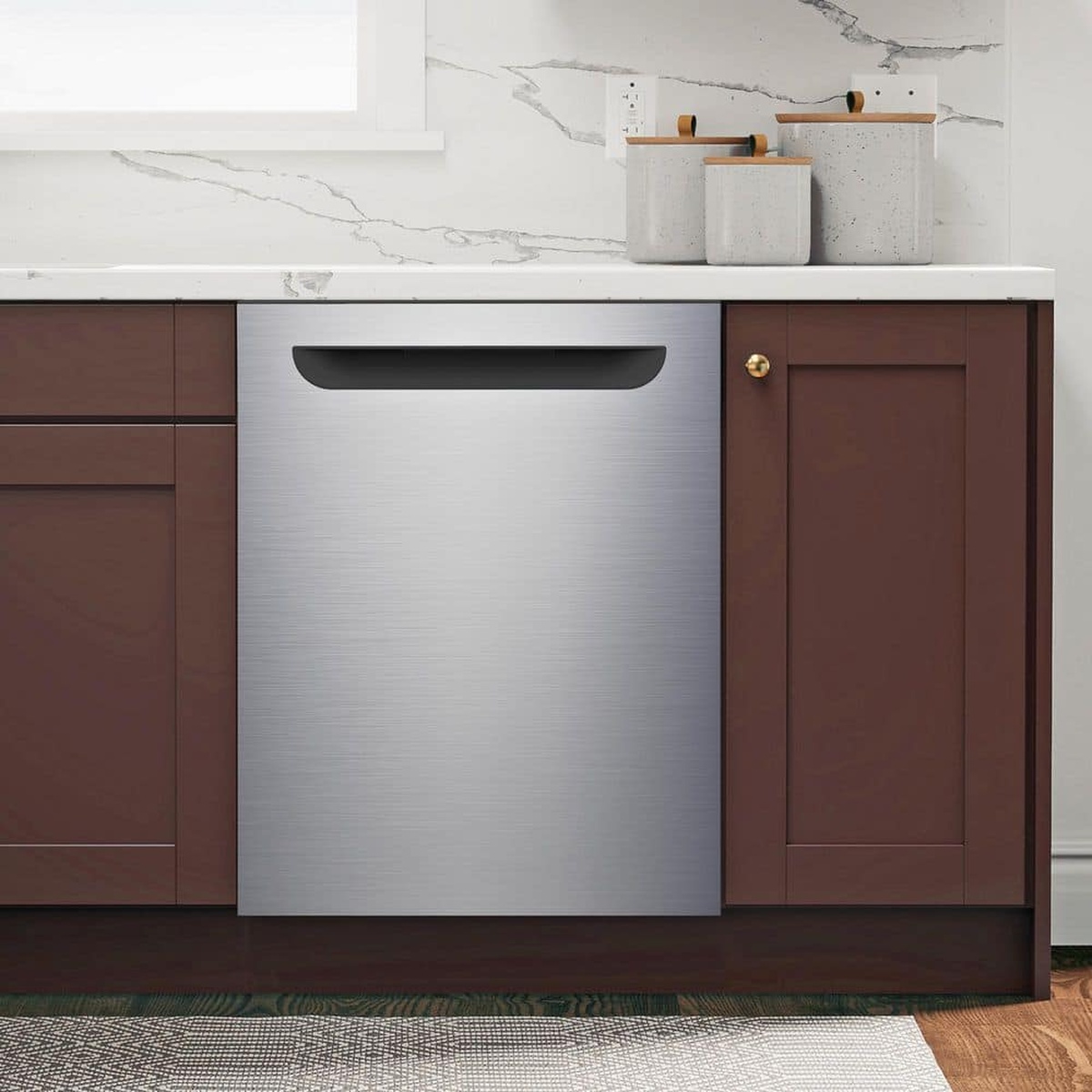 Stainless steel built-in dishwasher installed under a kitchen counter between cabinets
