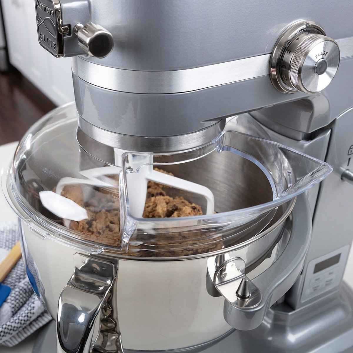 Close-up of the Kenmore Elite stand mixer head and stainless bowl with clear splash guard while mixing cookie dough