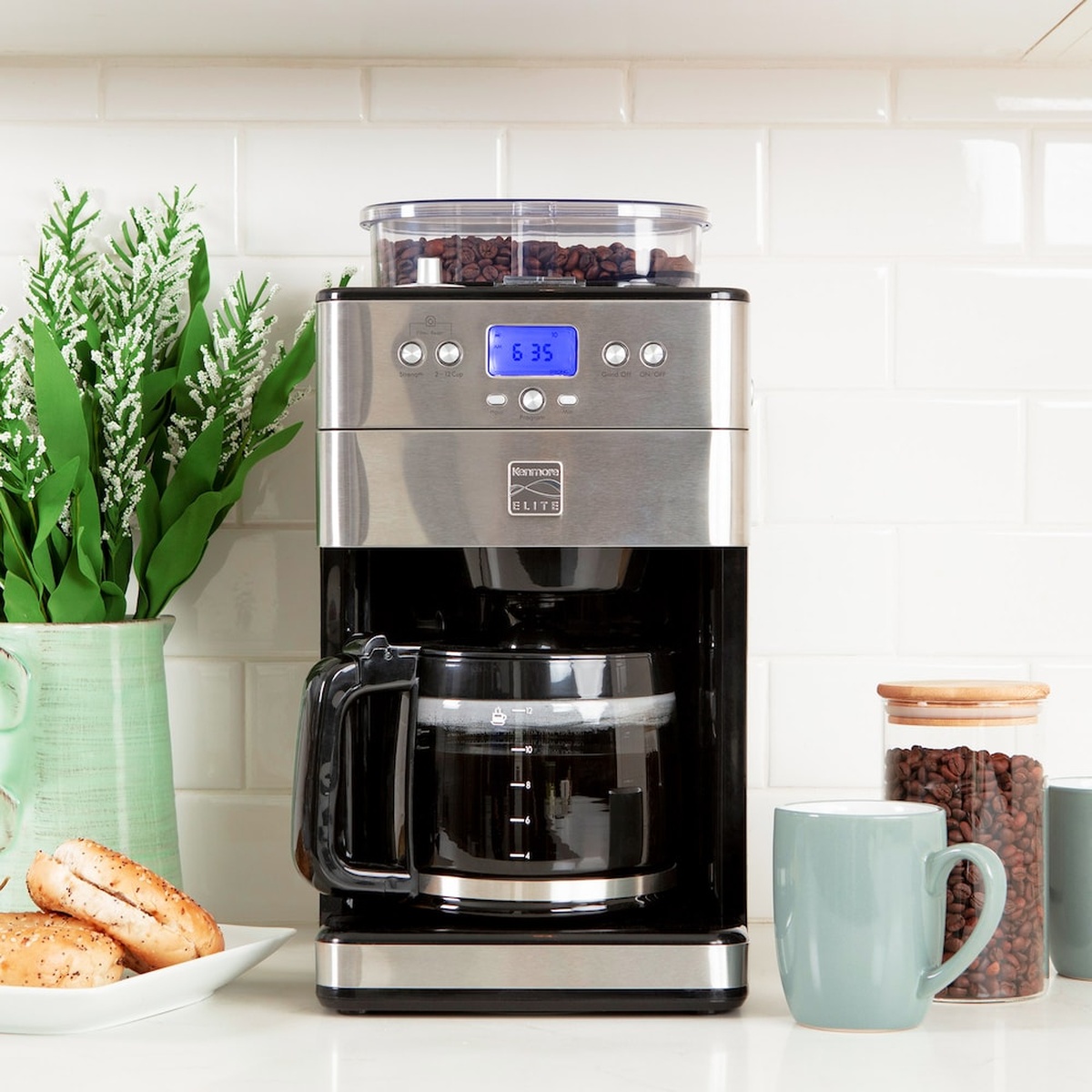 Kenmore Elite grind and brew coffee maker on a kitchen counter with a mug and coffee beans nearby