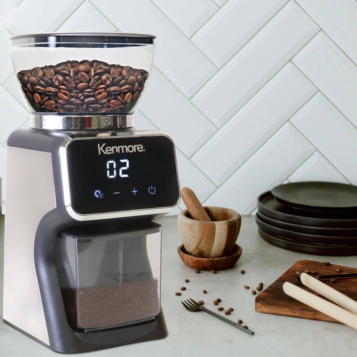 Kenmore conical burr coffee grinder on a kitchen counter with bean hopper and grounds bin visible.