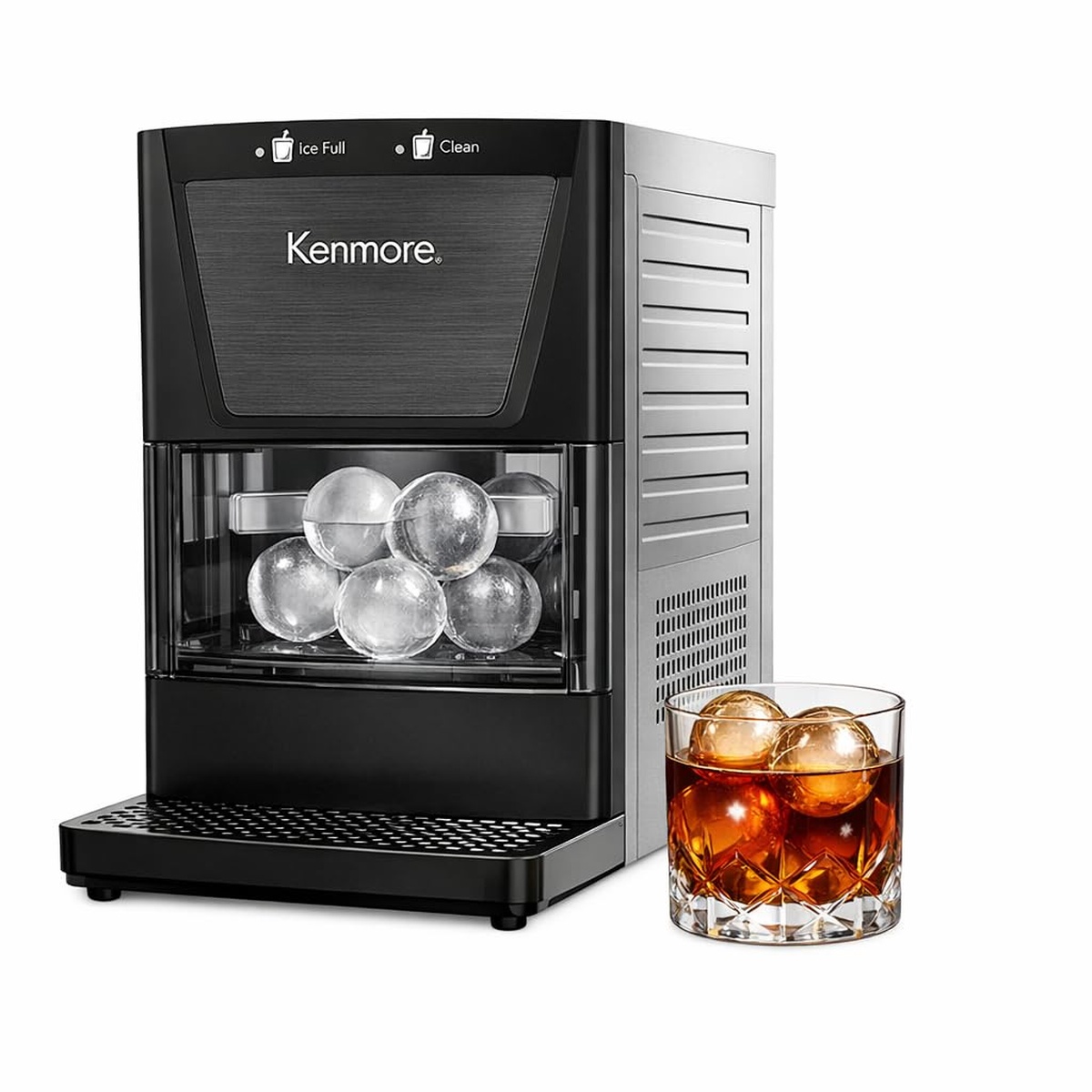 Kenmore countertop ice sphere maker with clear ice balls visible in the bin next to a glass of whisky