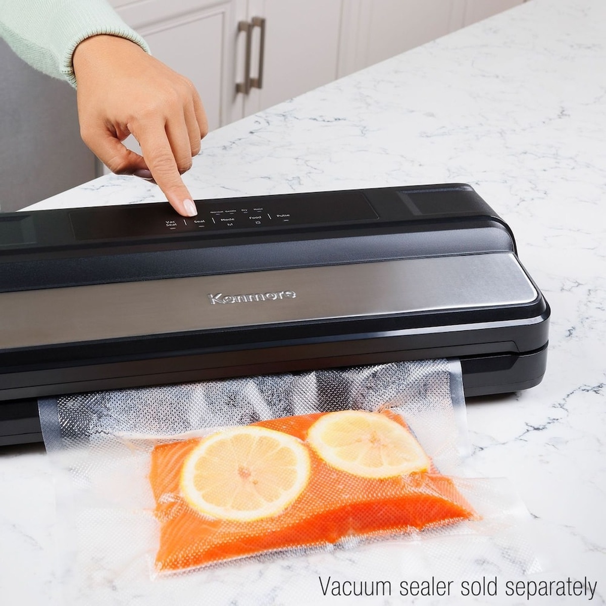 Kenmore countertop vacuum sealer sealing a textured bag with sliced citrus inside; text notes vacuum sealer sold separately