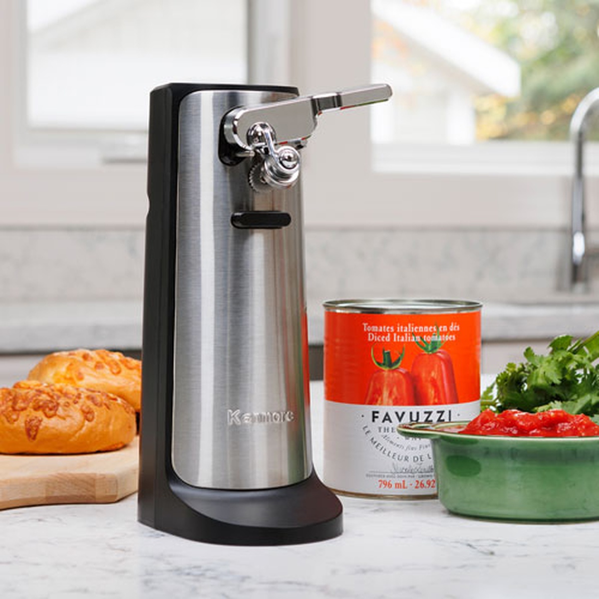 Kenmore electric can opener on a kitchen counter next to a can and prepared food