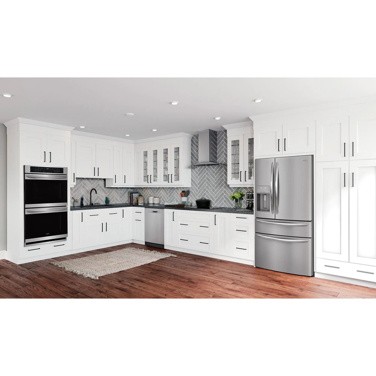 Frigidaire Gallery 4-door French door refrigerator in stainless steel installed in a contemporary white kitchen with dark hardwood floors