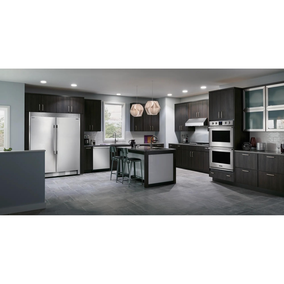 Complete Frigidaire Professional kitchen suite including side-by-side refrigerator, dishwasher, gas cooktop, and wall ovens installed in a modern dark-cabinet kitchen with island seating