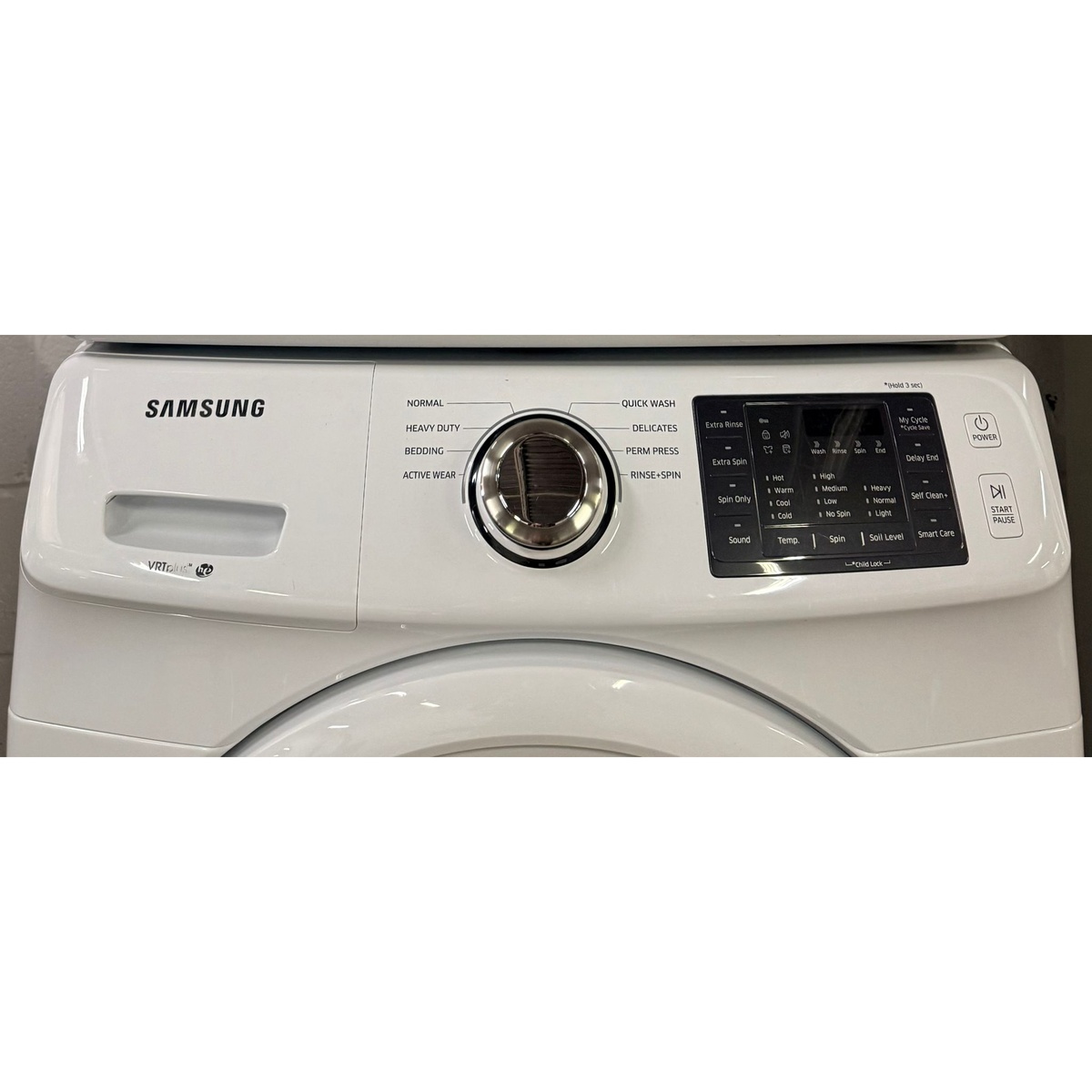 Close-up of the Samsung washer control panel showing cycle dial, digital display, and option buttons including Self Clean+ and Smart Care